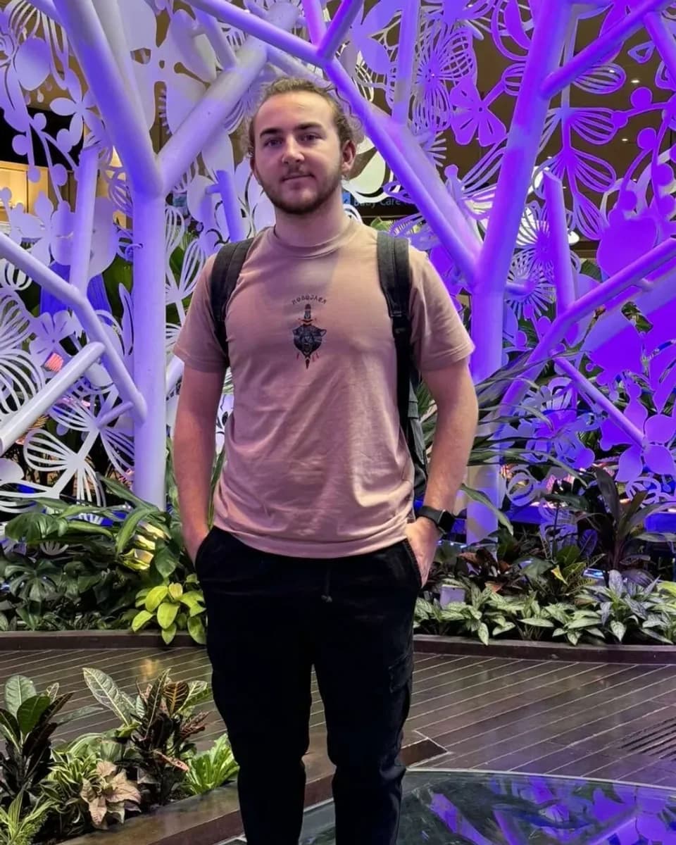 Ashton Jones standing in front of a lit sculpture of a tree
